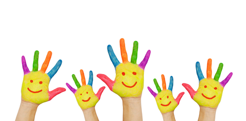 Children's smiling colorful hands raised up.