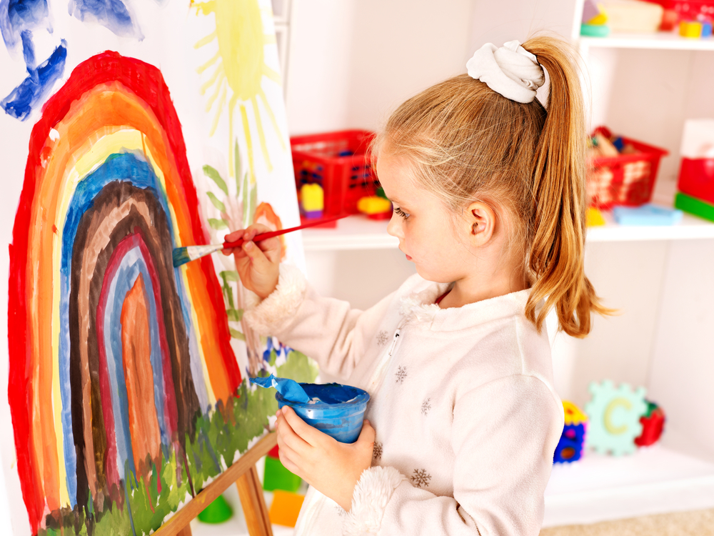 Child drawing on the easel.