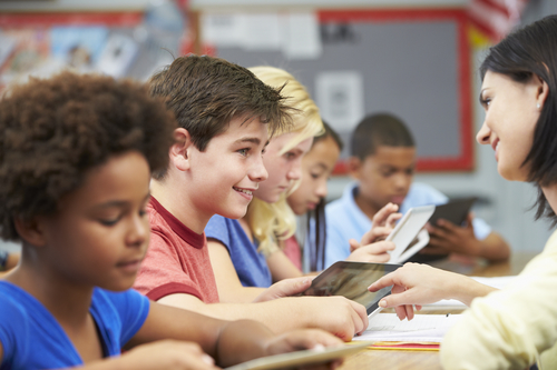 Pupils In Class Using Digital Tablet With Teacher