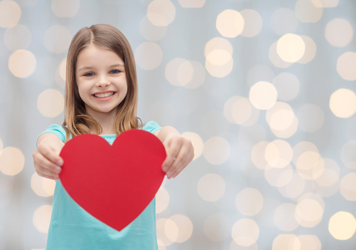 smiling little girl with red heart