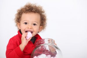 A cute kid eating marshmallow