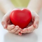 close up of child hands holding red heart