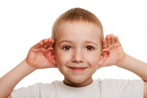 boy holding ears