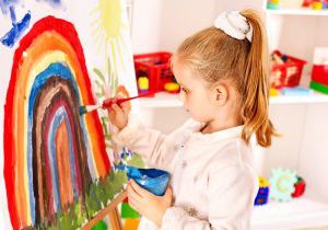 Child drawing on the easel.